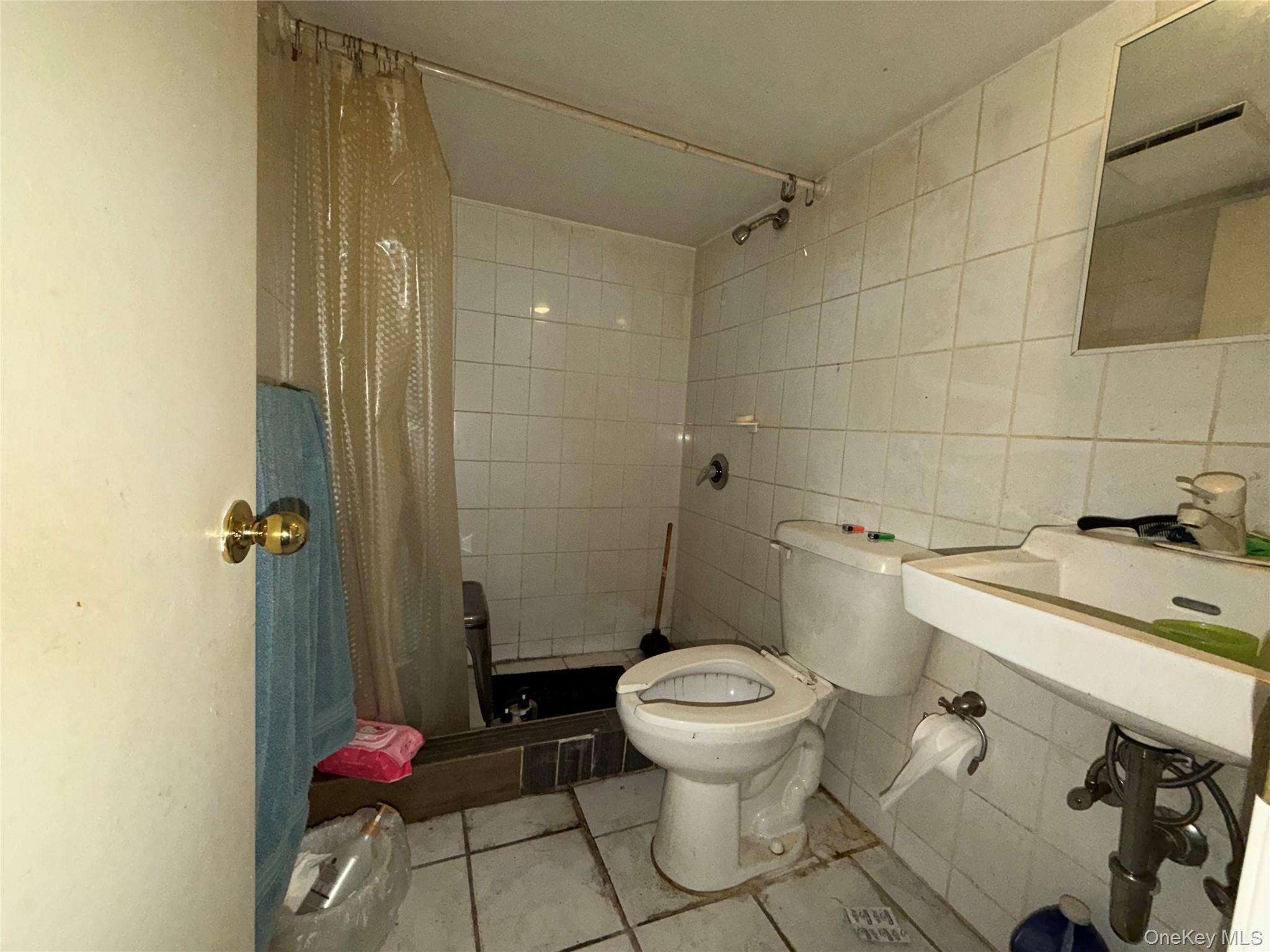 40-36 69th Street Queens, NY 11377 - Photo 25 of 32 a bathroom with a sink and a toilet
