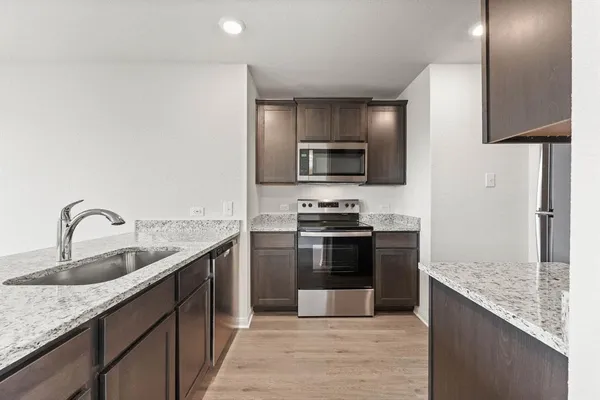 a kitchen with stainless steel appliances granite countertop a sink stove and refrigerator
