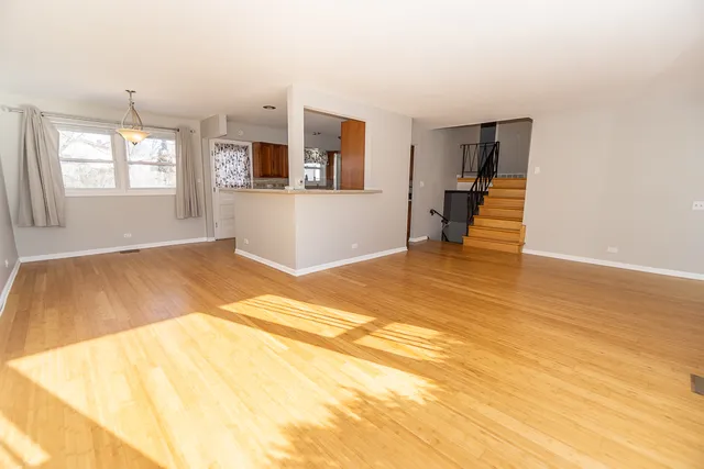a view of a bedroom with wooden floor and a window
