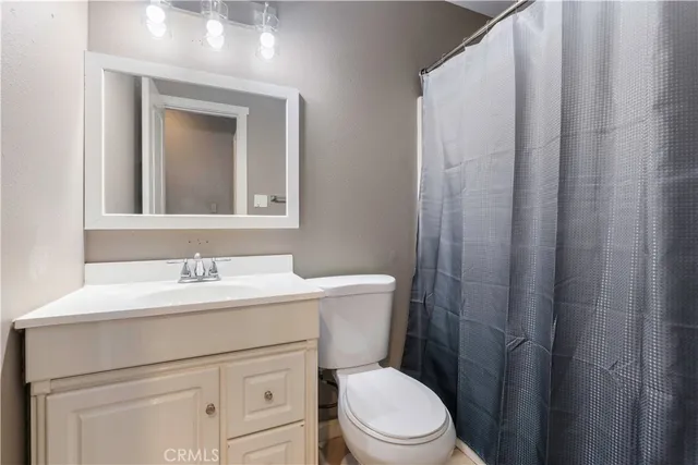 a bathroom with a toilet sink vanity and mirror