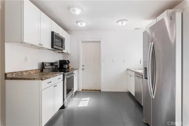a kitchen with stainless steel appliances granite countertop a refrigerator and a stove top oven