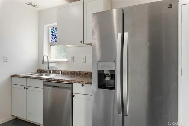 a kitchen with stainless steel appliances granite countertop a refrigerator and a sink