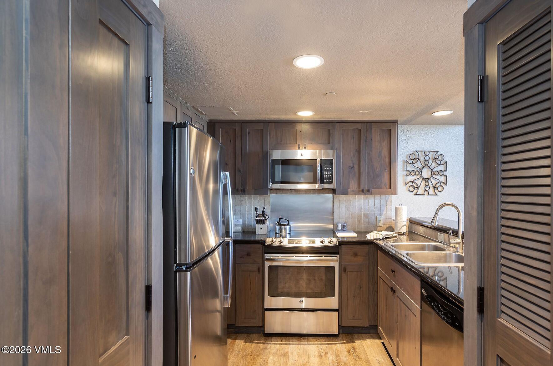 210 Offerson Road, Unit 41428 Beaver Creek, CO 81620 - Photo 5 of 25 a kitchen with a refrigerator and a sink