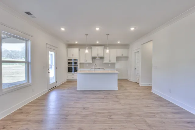 a large kitchen with a large window and stainless steel appliances
