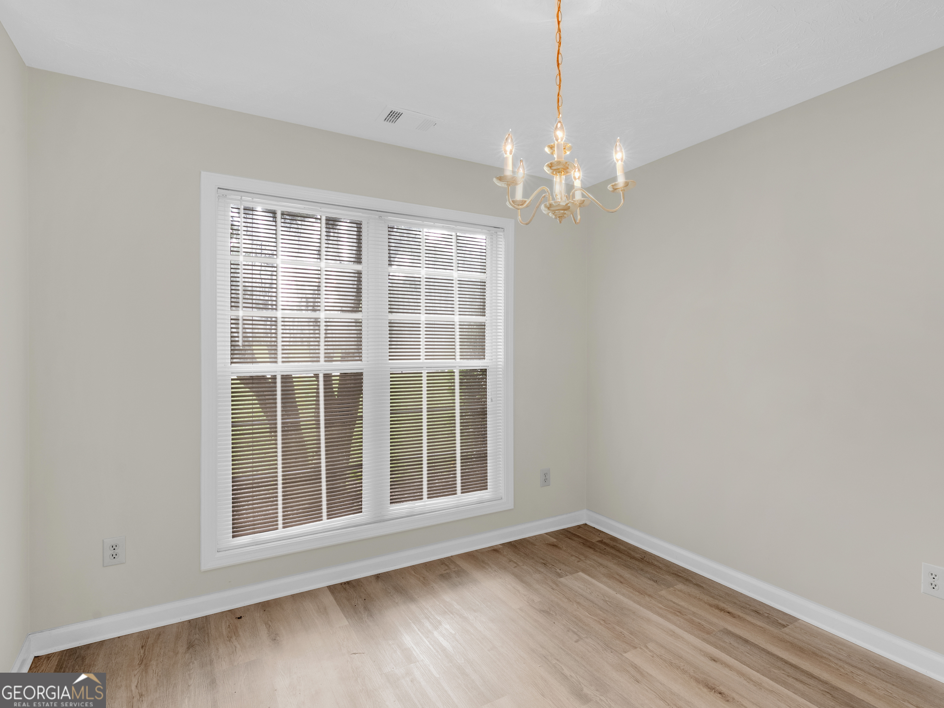 404 Northwind Place Stockbridge, GA 30281 - Photo 20 of 56 a view of an empty room with a window and wooden floor
