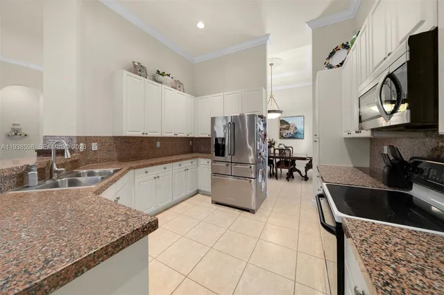 a kitchen with stainless steel appliances granite countertop a sink a stove top oven a counter space and cabinets