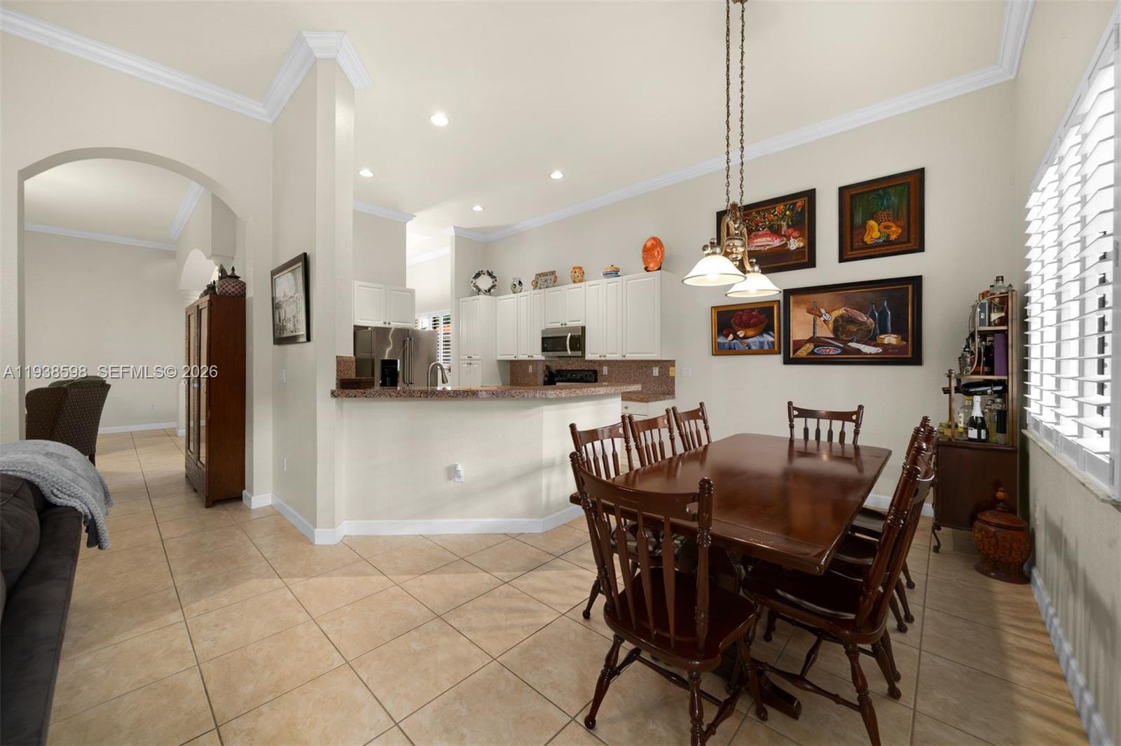 7548 Southwest 190th Street Cutler Bay, FL 33157 - Photo 14 of 53 a kitchen with stainless steel appliances kitchen island granite countertop a refrigerator a stove a microwave oven a dining table and chairs with wooden floor