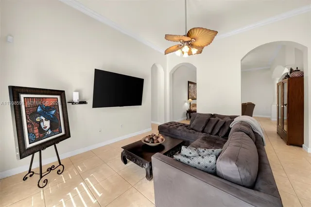 a living room with furniture a flat screen tv and a chandelier