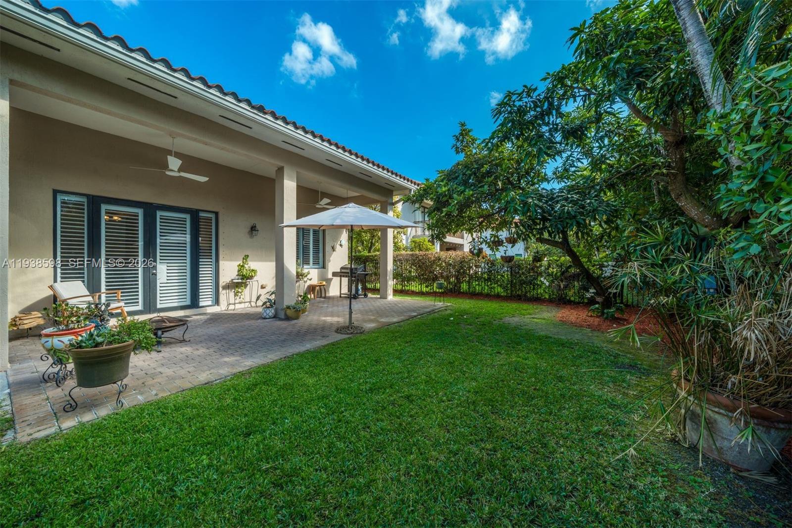 7548 Southwest 190th Street Cutler Bay, FL 33157 - Photo 33 of 53 a view of a patio with table and chairs potted plants and large tree