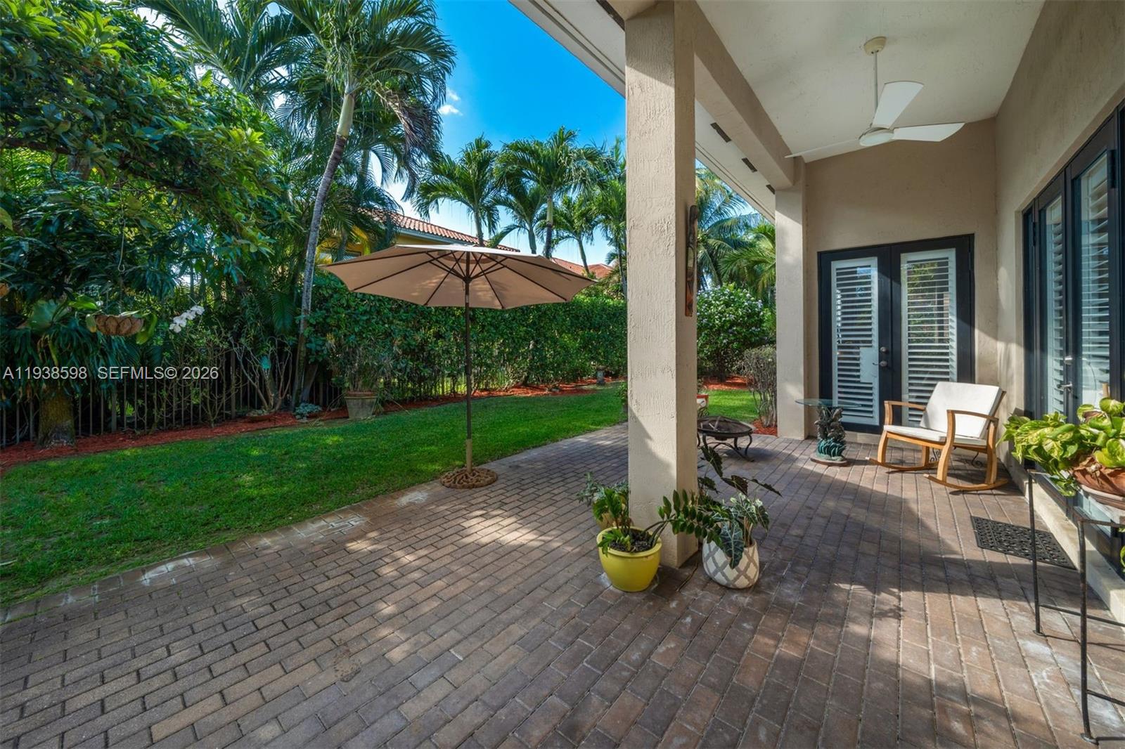 7548 Southwest 190th Street Cutler Bay, FL 33157 - Photo 36 of 53 a view of a patio with table and chairs potted plants and floor to ceiling window