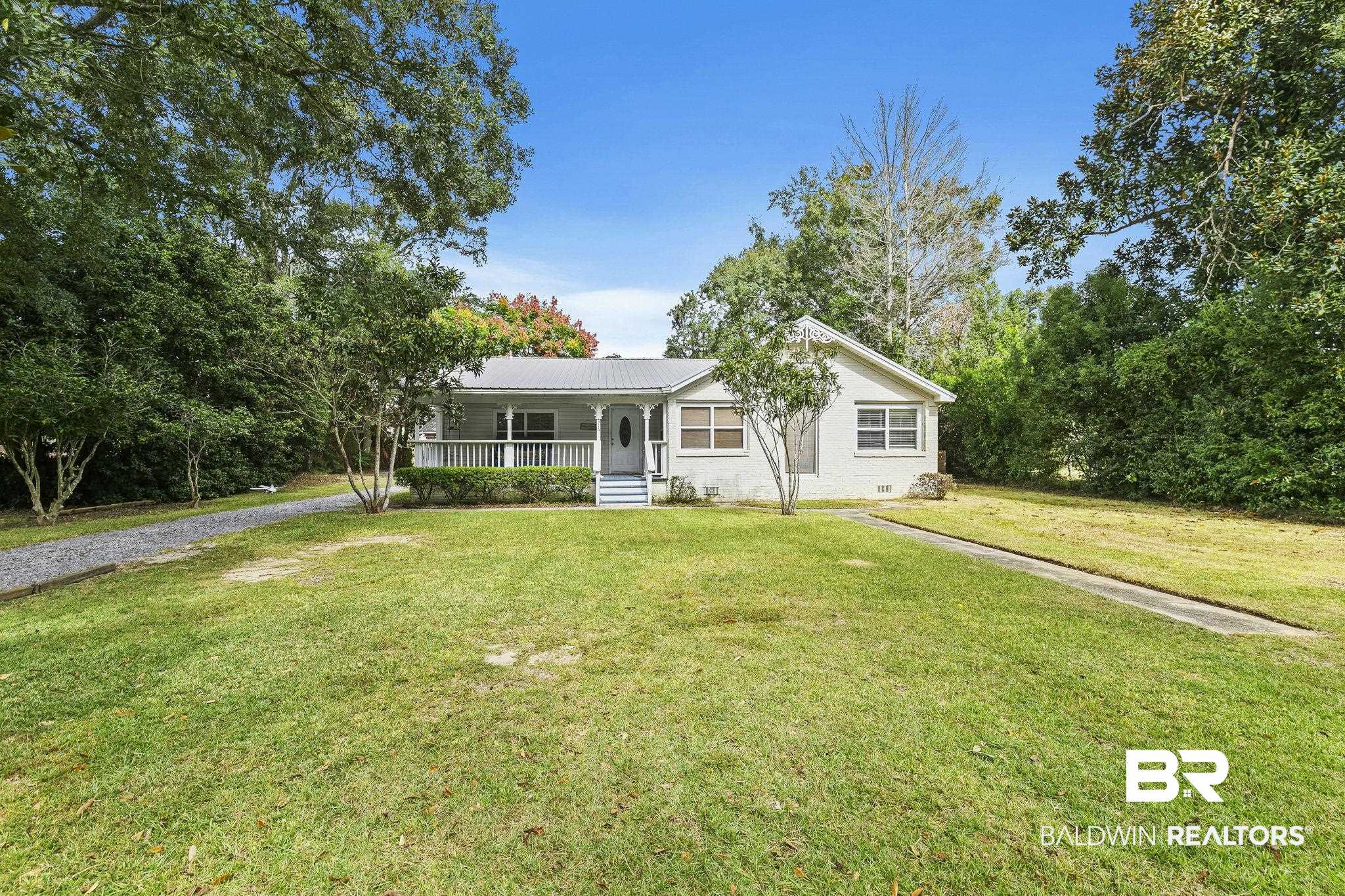 316 West Orchid Avenue Foley, AL 36535 - Photo 1 of 38 Ranch-style house with covered porch, a front lawn, a metal roof, and brick siding