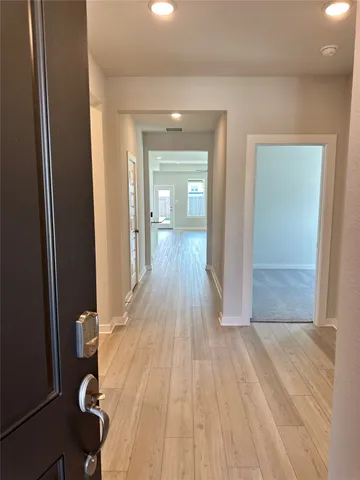 a view of a hallway with wooden floor