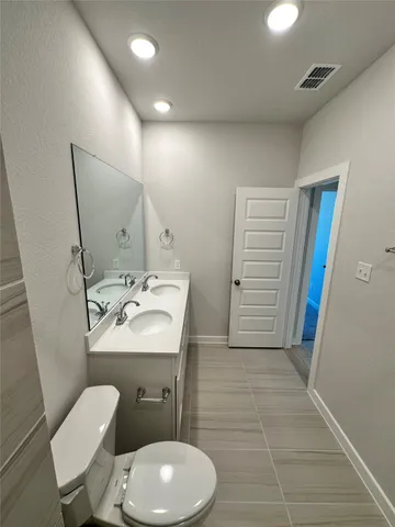 a bathroom with a toilet sink and mirror