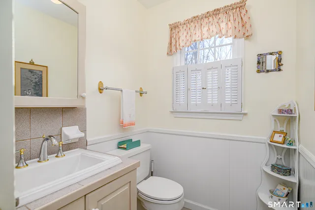 a bathroom with a sink vanity mirror and toilet