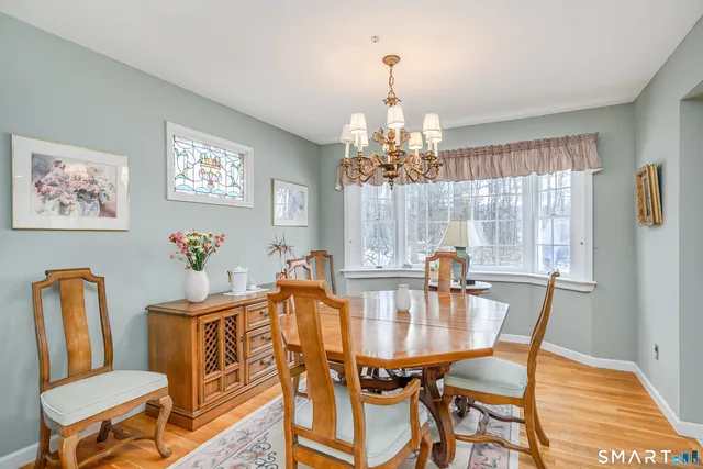 a dining room with furniture a chandelier and wooden floor