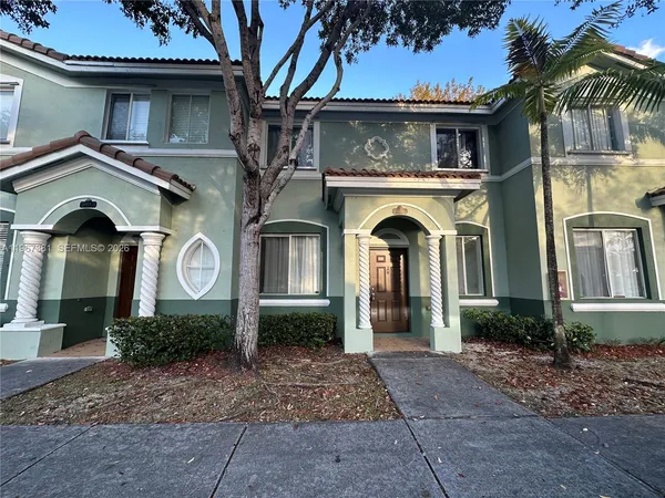 a view of a house with large windows and a yard
