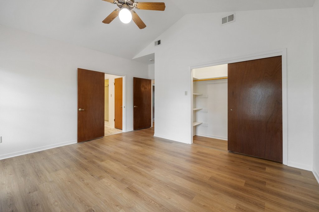 244 Woodway Elgin, TX 78621 - Photo 22 of 40 a view of an empty room with wooden floor and a ceiling fan