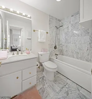 a bathroom with a toilet a sink a mirror a bathtub and shower