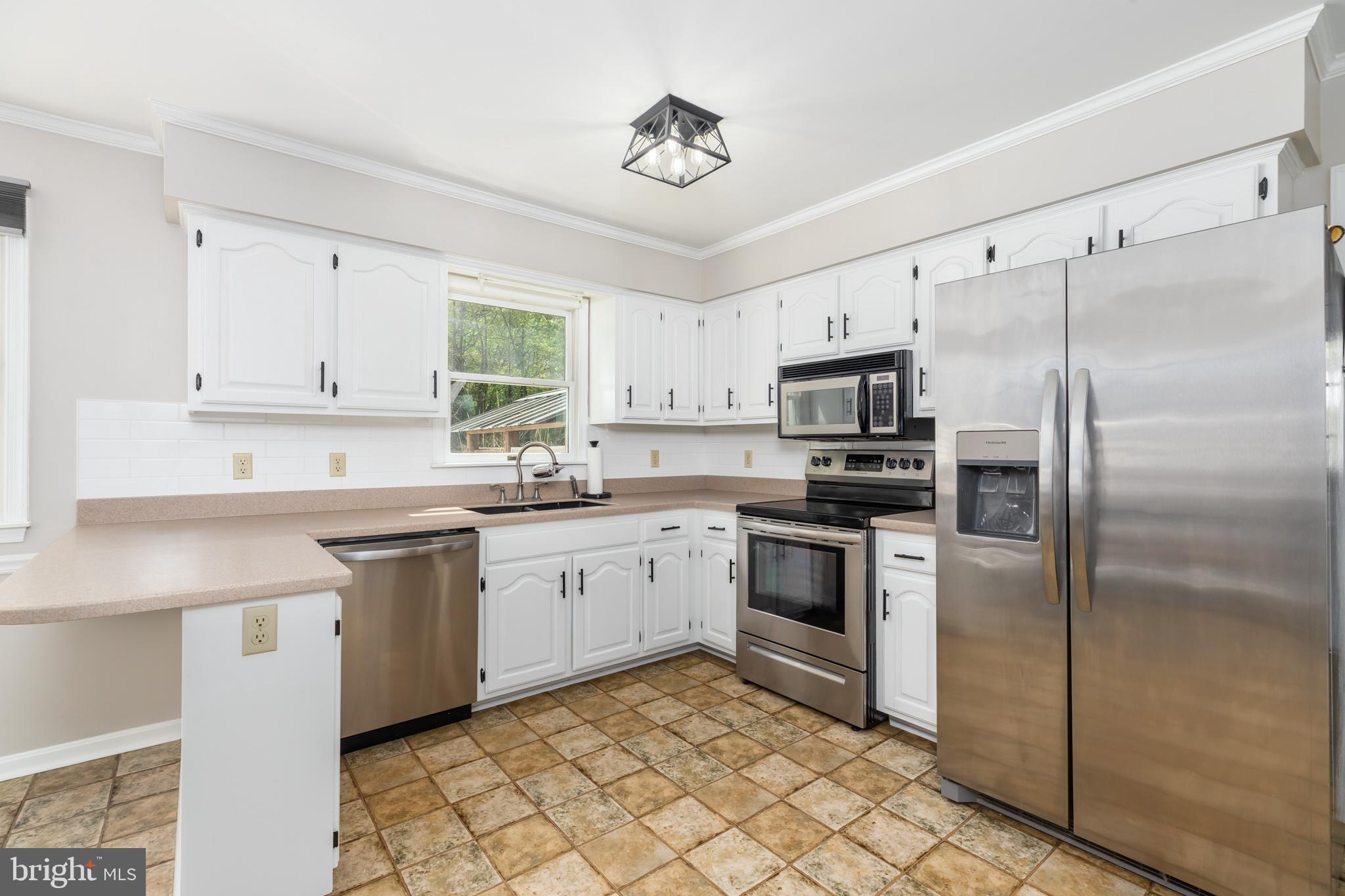 35588 Lizzard Hill Road Frankford, DE 19945 - Photo 11 of 39 a kitchen with granite countertop white cabinets stainless steel appliances and a window
