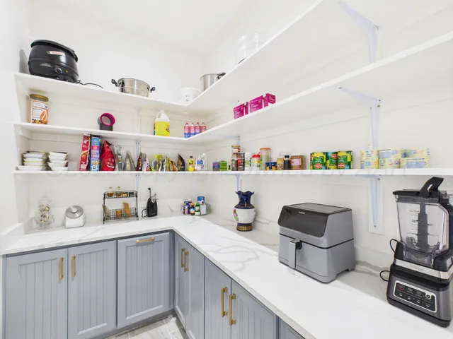 a kitchen with a sink dishwasher stove and white countertops with wooden floor