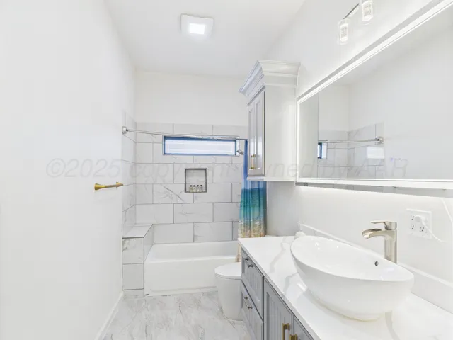 a bathroom with a granite countertop sink a toilet and bathtub