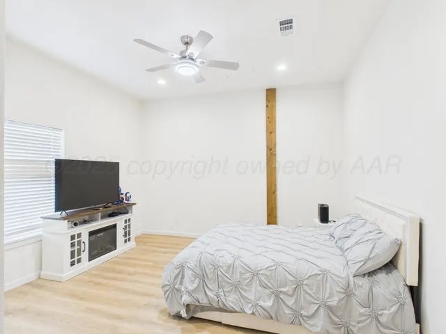 a bedroom with a bed and a flat screen tv