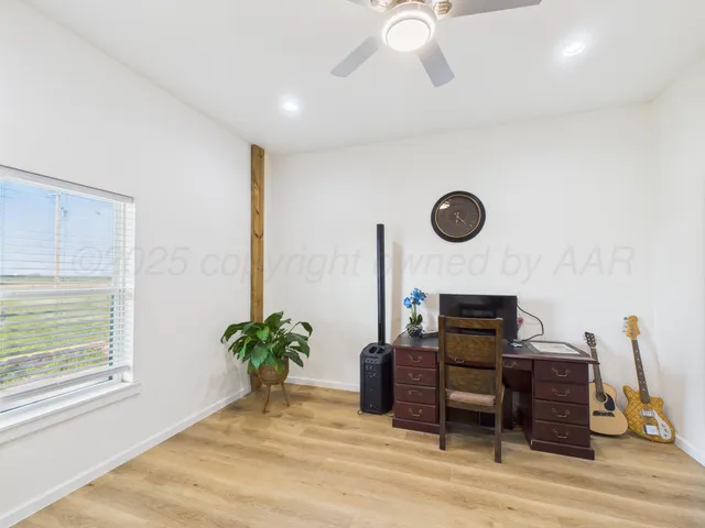 a view of a workspace with furniture and a window