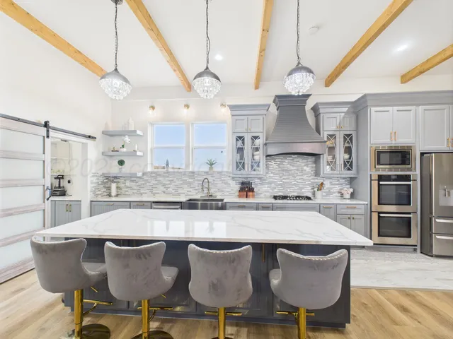 a kitchen with granite countertop a table chairs stove and cabinets