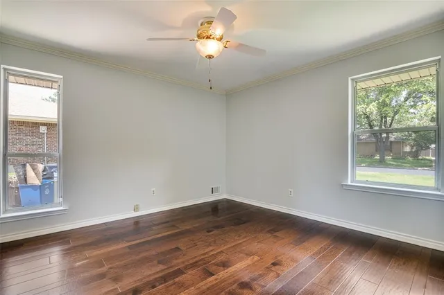 a view of a room with wooden floor and a ceiling fan