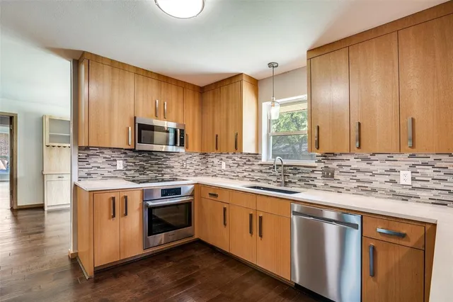 a kitchen with stainless steel appliances granite countertop a stove and a sink