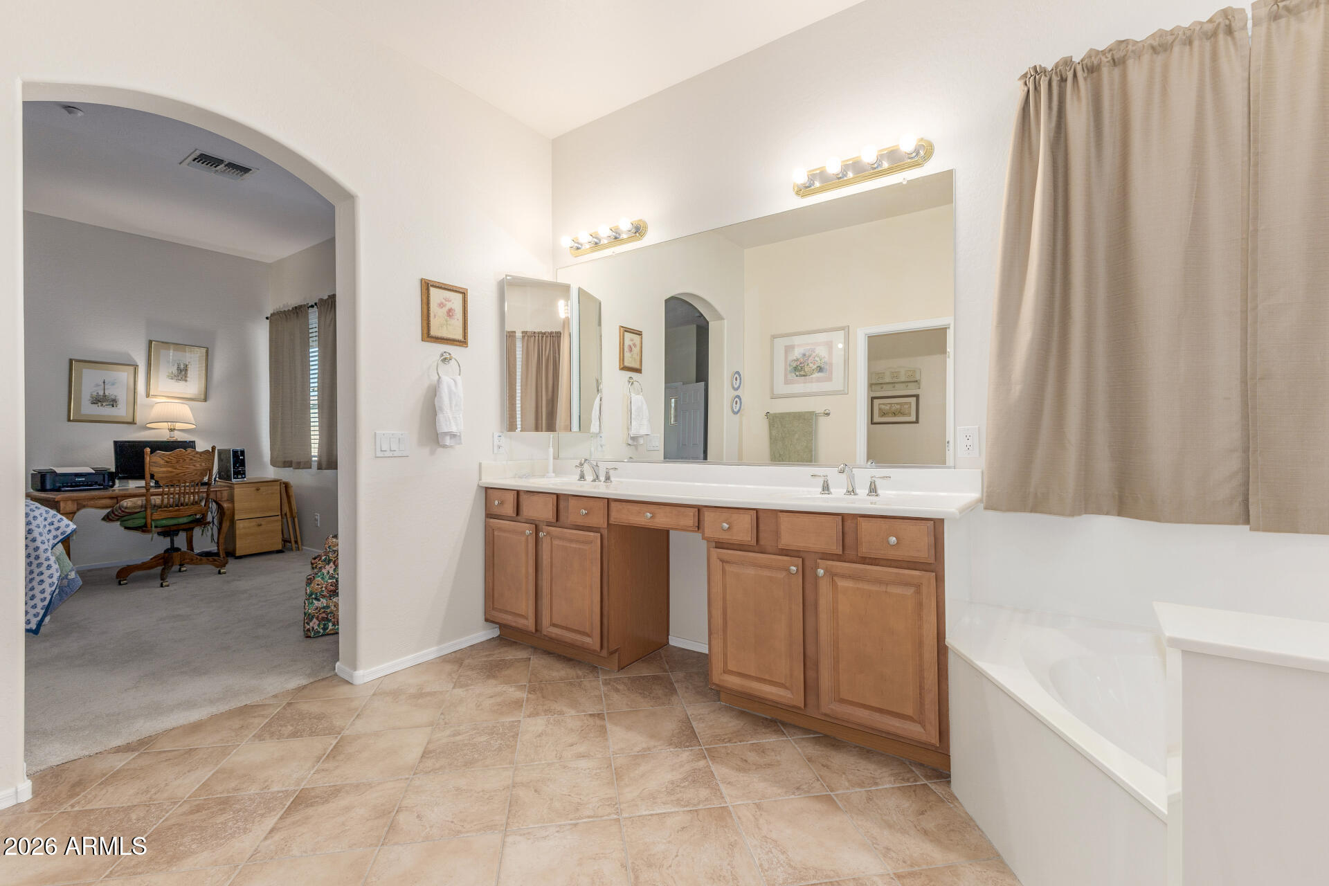 12731 West Eagle Ridge Lane Peoria, AZ 85383 - Photo 18 of 88 a spacious bathroom with a double vanity sink a mirror and a bathtub