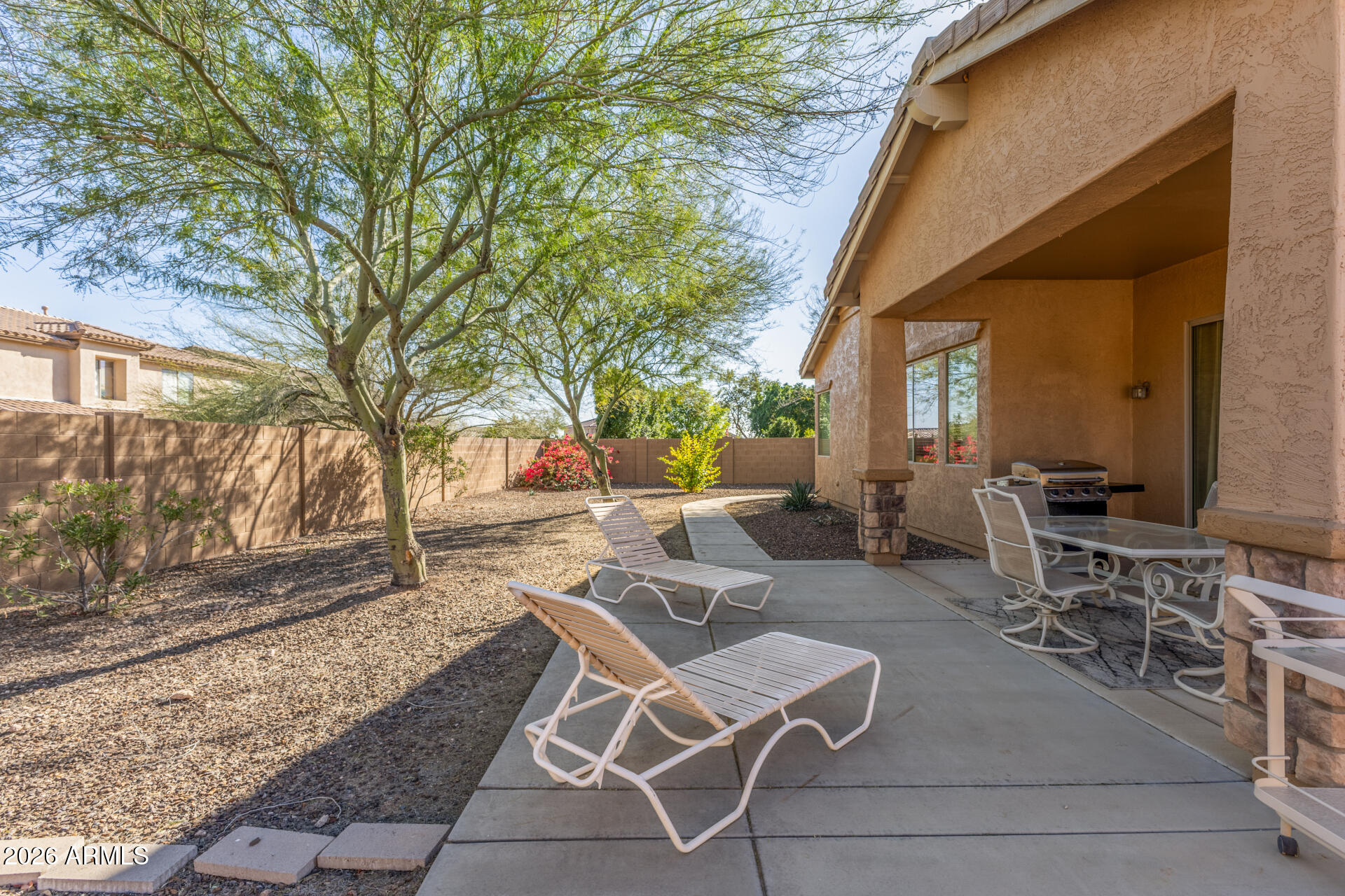 12731 West Eagle Ridge Lane Peoria, AZ 85383 - Photo 26 of 88 a view of a patio with table and chairs and couches with wooden fence