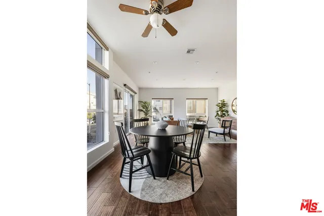 a kitchen with stainless steel appliances a table chairs refrigerator and cabinets