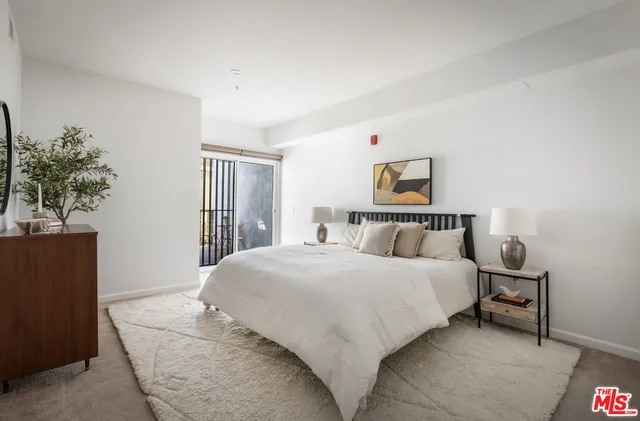 a bedroom with a bed and a painting on the wall