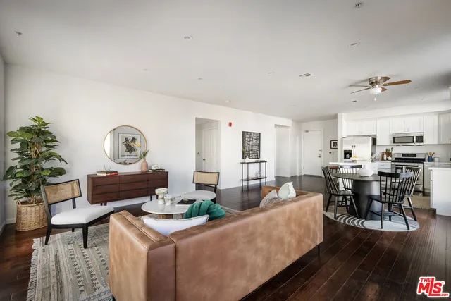 a living room with furniture and a dining table with wooden floor