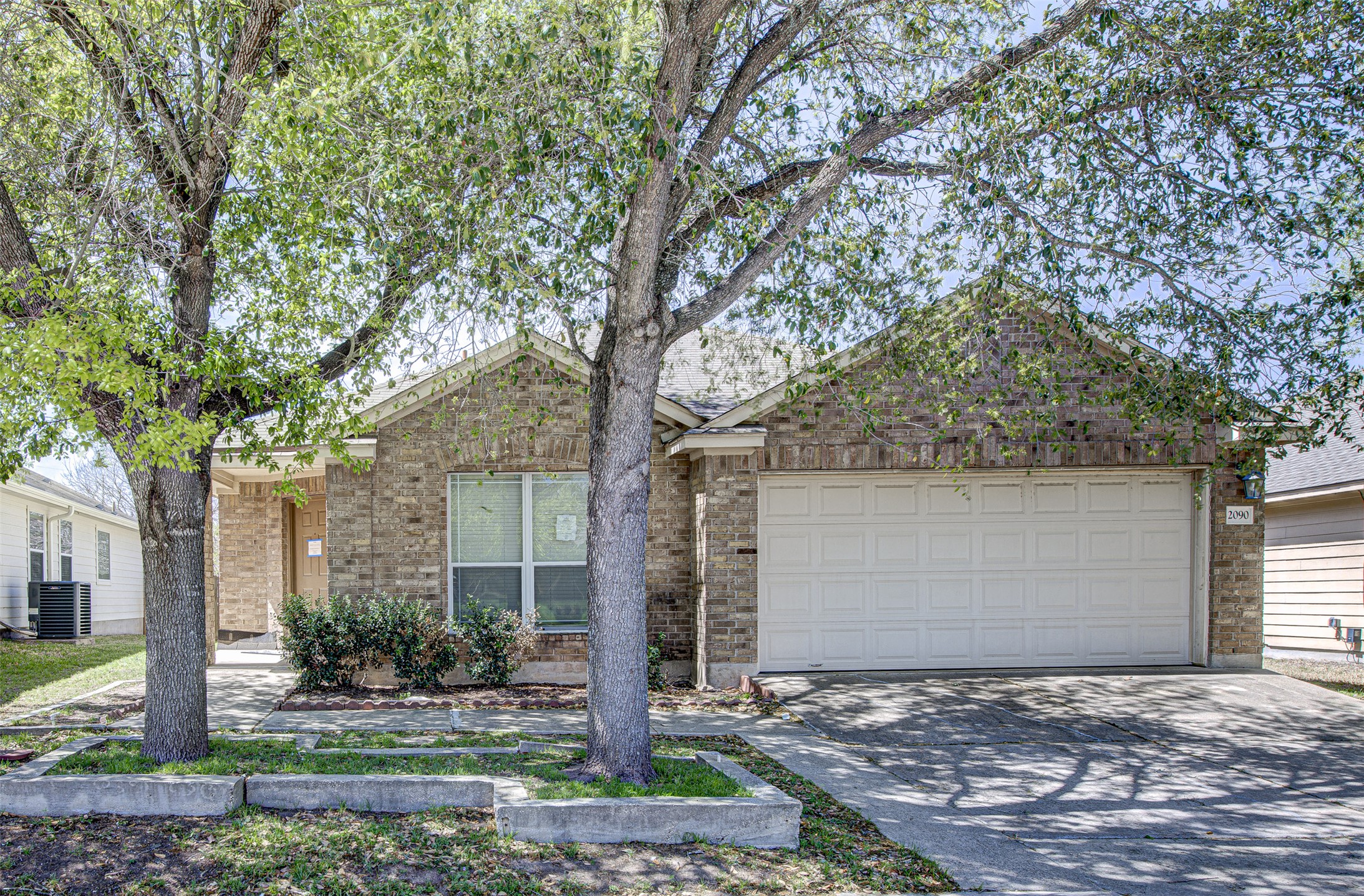 2090 Intrepid Drive Buda, TX 78610 - Photo 2 of 24 Ranch-style house with brick siding, concrete driveway, and an attached garage