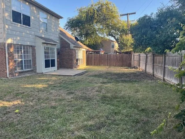 a view of a yard in front of a house with large trees