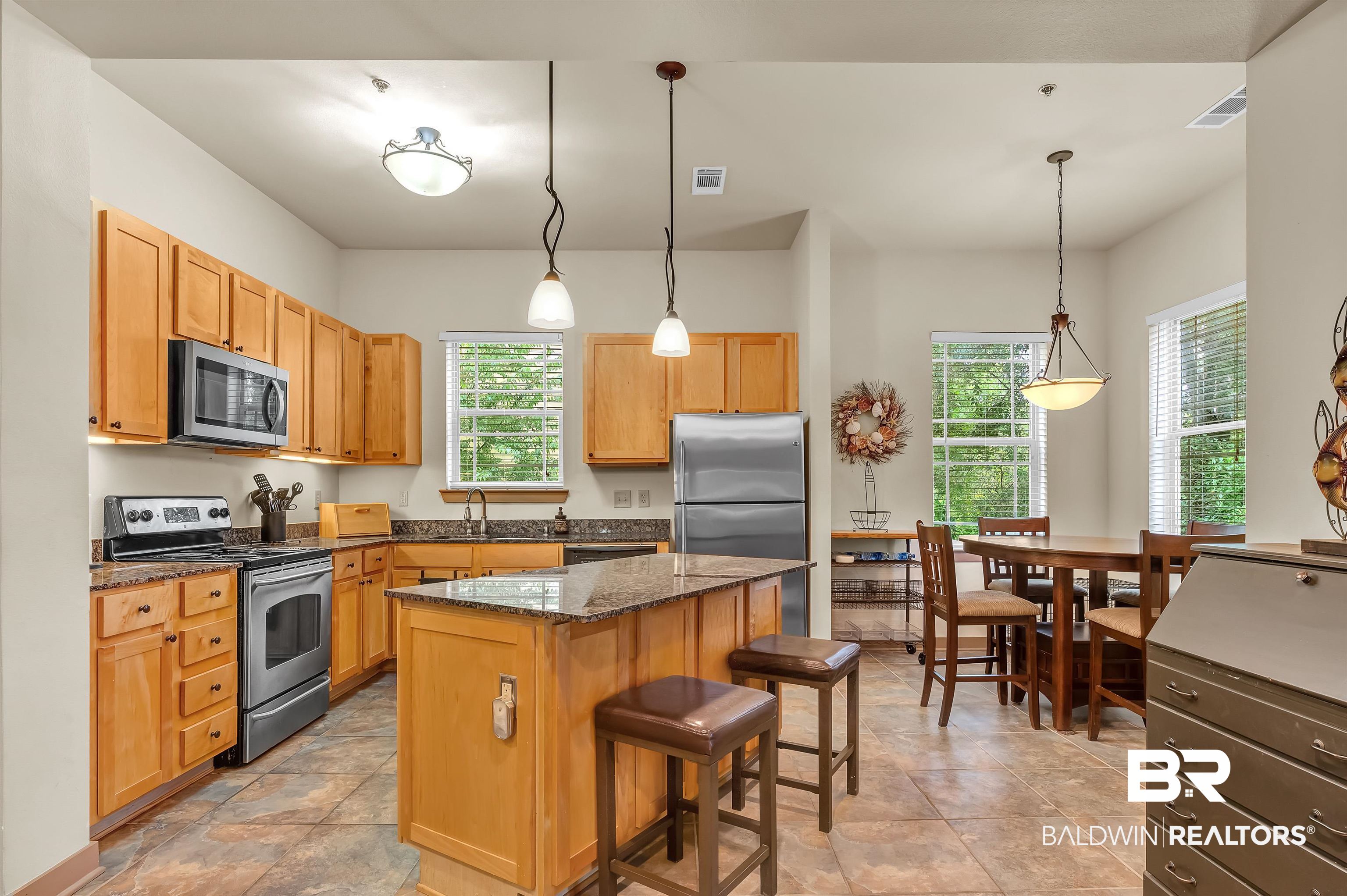 1430 Regency Road, Unit C201 Gulf Shores, AL 36542 - Photo 3 of 54 Kitchen with stainless steel appliances, a kitchen island, plenty of natural light, and a breakfast bar area