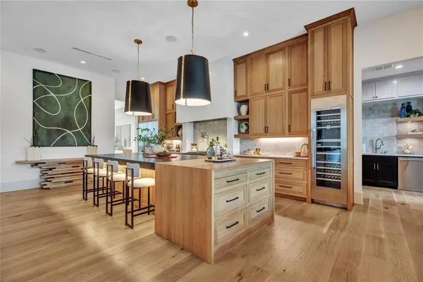 a kitchen with stainless steel appliances kitchen island granite countertop a stove a sink and a refrigerator