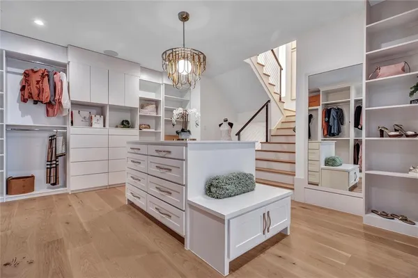 a kitchen with stainless steel appliances a white cabinets and a wooden floor