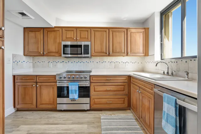 a kitchen with stainless steel appliances granite countertop a stove microwave and sink
