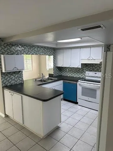 a kitchen with granite countertop a sink stove and cabinets
