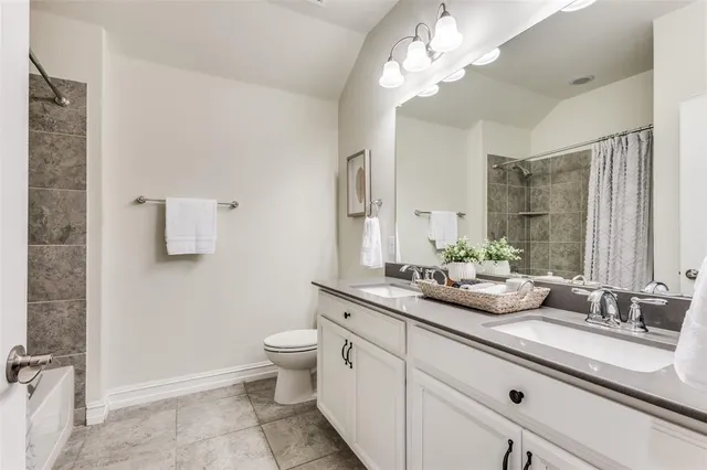 a bathroom with a double vanity sink mirror and toilet