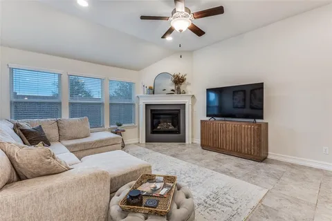 a living room with furniture a fireplace and a flat screen tv