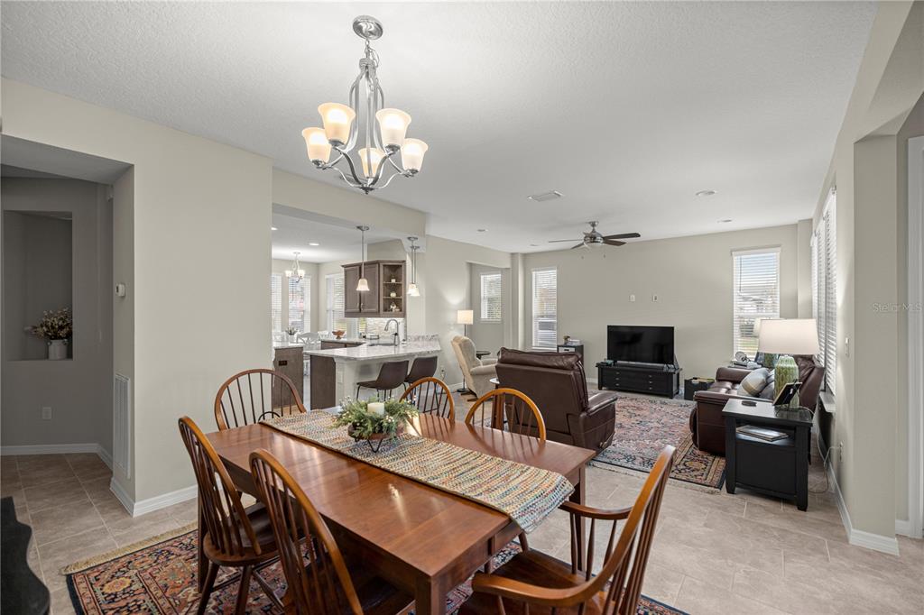 5504 Northwest 40th Loop Ocala, FL 34482 - Photo 13 of 31 a view of a dining room with furniture a chandelier and wooden floor
