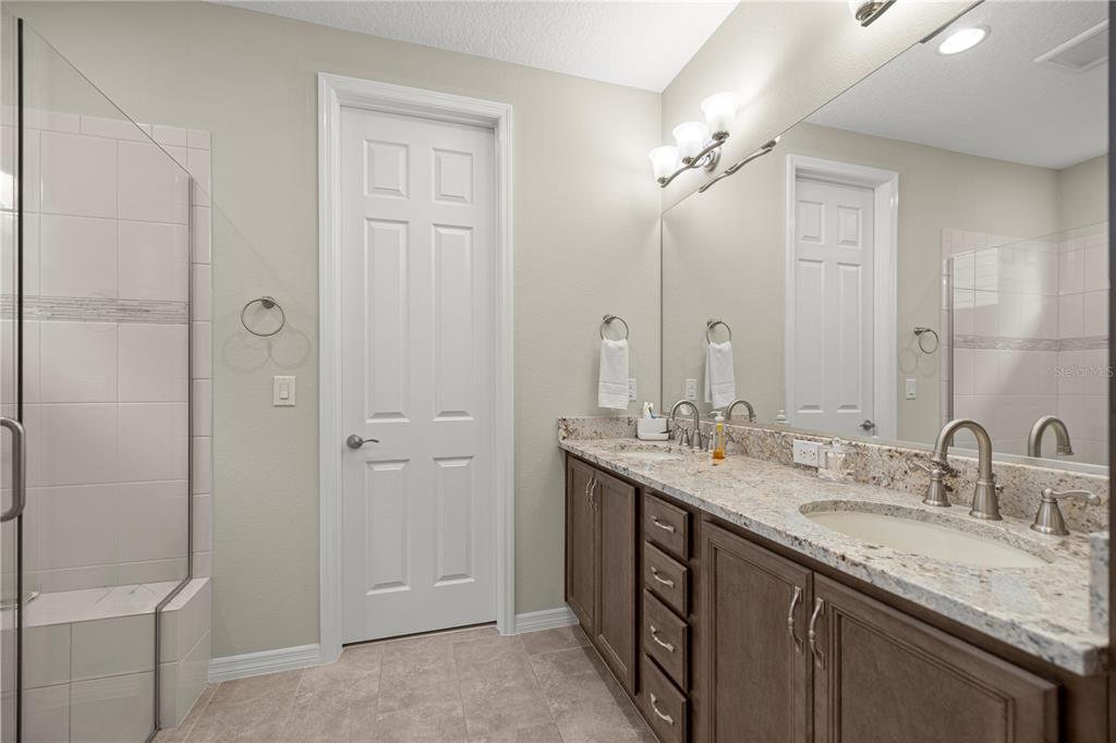 5504 Northwest 40th Loop Ocala, FL 34482 - Photo 18 of 31 a bathroom with a granite countertop sink two mirror and a