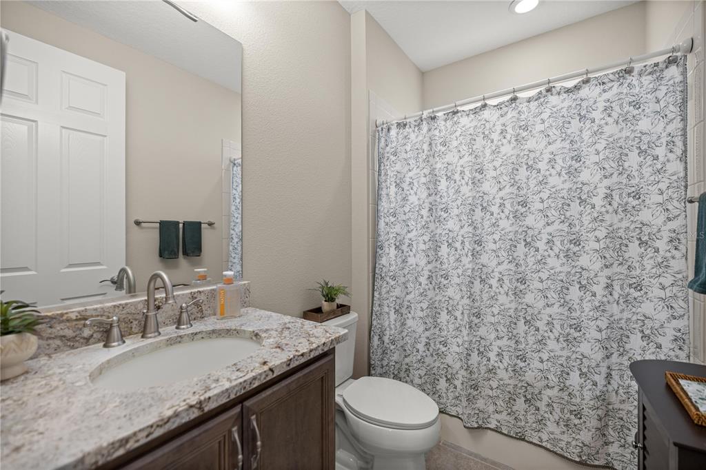 5504 Northwest 40th Loop Ocala, FL 34482 - Photo 21 of 31 a bathroom with a granite countertop sink toilet and shower