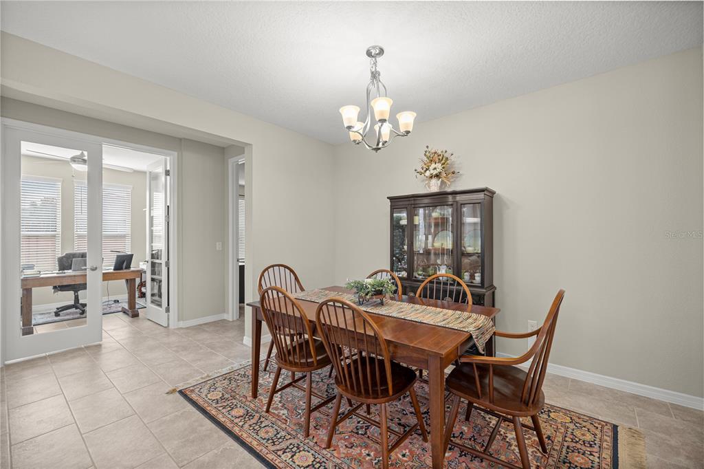 5504 Northwest 40th Loop Ocala, FL 34482 - Photo 8 of 31 a view of a dining room with furniture and chandelier