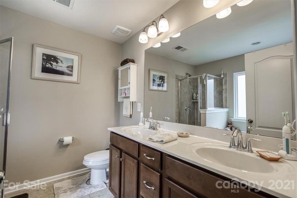 78166 Rillstone Drive Lancaster, SC 29720 - Photo 14 of 25 a bathroom with a granite countertop sink a toilet and a mirror