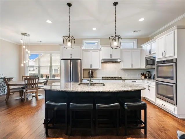 a kitchen with kitchen island granite countertop a stove sink and microwave